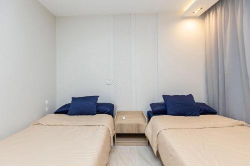 two beds with blue pillows in a room at B15/87/31 · 3BR Haven in B15 Madinaty in Madinaty