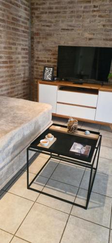 a living room with a tv and a coffee table at Amplio Duplex frente a Parque Benegas in Godoy Cruz