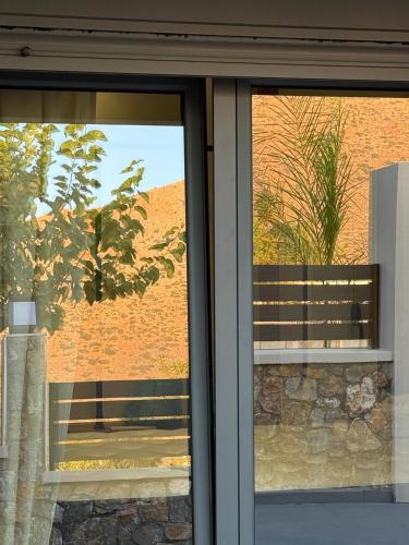 a glass window with a view of a brick wall at Theros Residence in Stavros