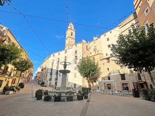 a large building with a clock tower in a street at Casa Ariadna in Bocairent