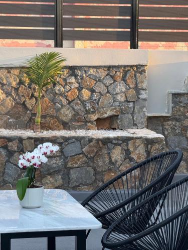 a table and two chairs with a vase of flowers at Theros Residence in Stavros