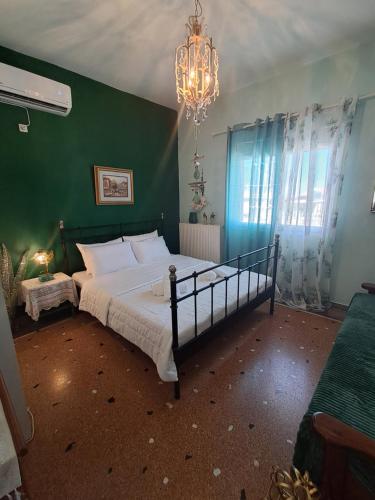 a bedroom with a large bed with a green wall at Villa Excelsior in Kórinthos
