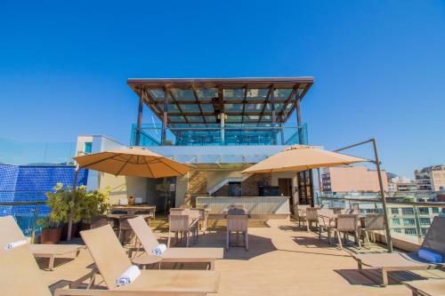 a patio with tables and chairs and umbrellas at Arena Ipanema Hotel in Rio de Janeiro