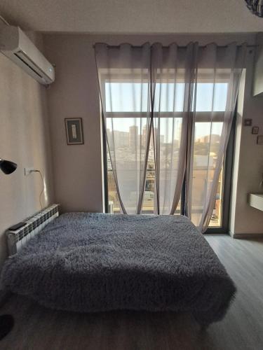 una camera da letto con un letto e una grande finestra di Appartamento a Baku