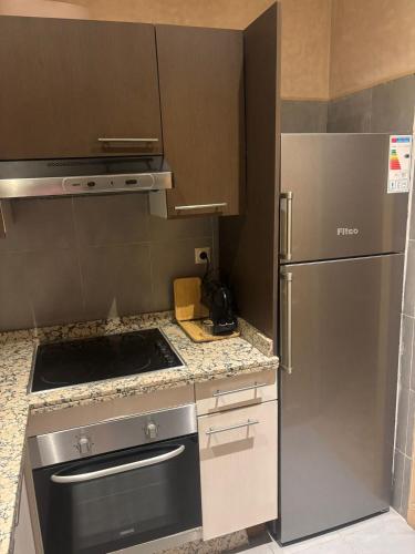 a kitchen with a stove and a refrigerator at Appartement avec vue sur l'Atlas et piscine in Marrakech