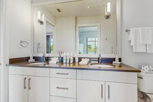 a bathroom with two sinks and a large mirror at SoCe Flats 204 in Naples