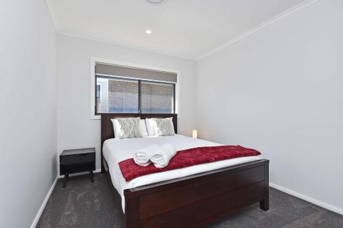 a bedroom with a bed with two towels on it at Huntlee Heights in North Rothbury