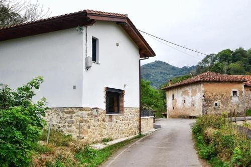 ein weißes Haus auf einer Straße neben einem Gebäude in der Unterkunft vivienda vacacional LA PAULA in Sirviella