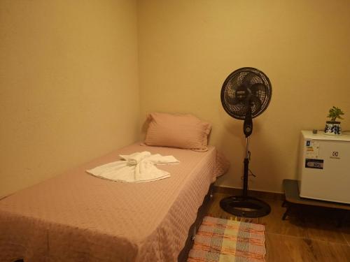 Habitación con cama y ventilador junto a ella en Casa de Luz - Lar na Serra - Suíte - Duplo ou Triplo - N5, en Miguel Pereira