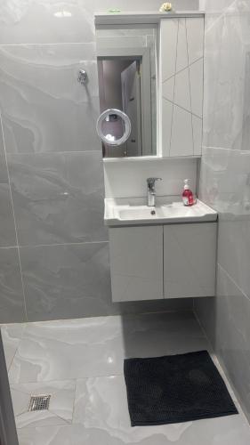 un bagno bianco con lavandino e specchio di Appartamento a Baku