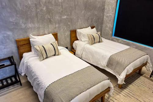 a room with two beds and a chalk board at Seabird - Villa 10 in Placencia Village