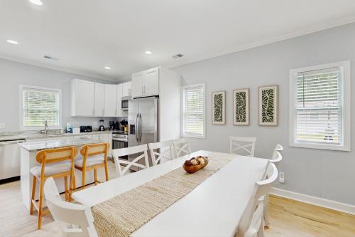 a white kitchen with a dining table and chairs at Pawleys PARadise in Pawleys Island