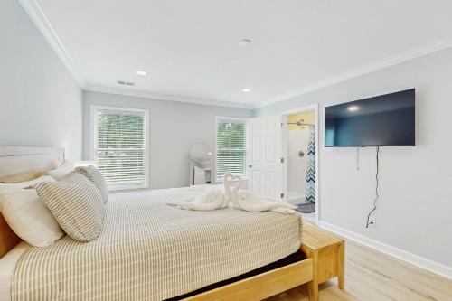 a bedroom with a bed with a tv on the wall at Pawleys PARadise in Pawleys Island