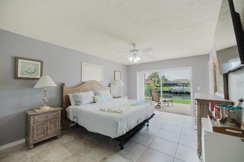 une chambre avec un lit et un ventilateur de plafond dans l'établissement Beautiful electric-heated pool home on Sailboat Access Canal - Villa Francis, à Cape Coral
