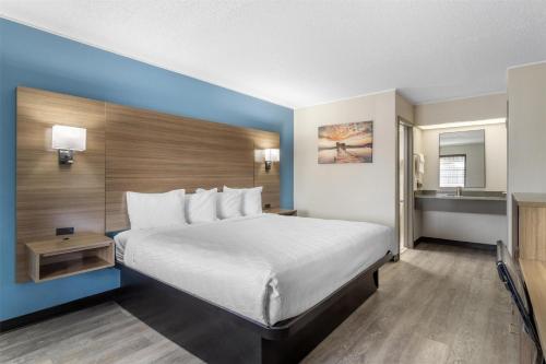 a hotel room with a large bed and a bathroom at SureStay by Best Western Victoria in Victoria