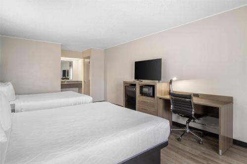 a hotel room with two beds and a desk with a computer at SureStay by Best Western Victoria in Victoria