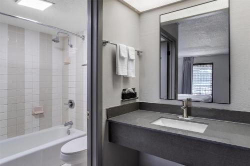 a bathroom with a sink and a toilet and a mirror at SureStay by Best Western Victoria in Victoria
