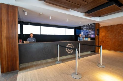 two people standing at a counter in a lobby at Arena Ipanema Hotel in Rio de Janeiro