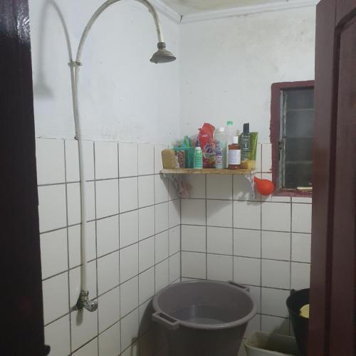 un bagno con wc in una stanza piastrellata bianca di Studio meublé a Douala