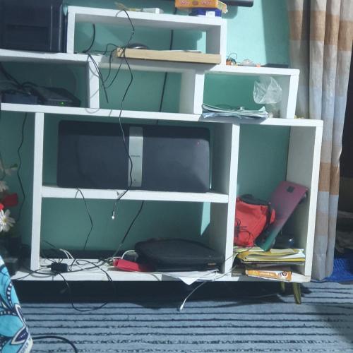 una libreria bianca con una TV sopra di Studio meublé a Douala