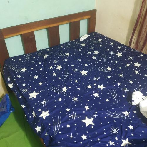 un letto con un piumone blu con delle stelle sopra di Studio meublé a Douala