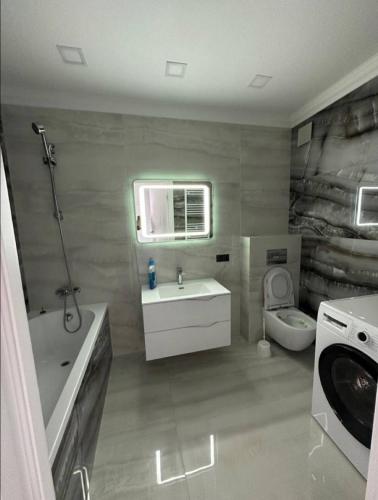un bagno con lavandino, WC e lavatrice di ApartHotel city centrum a Chişinău