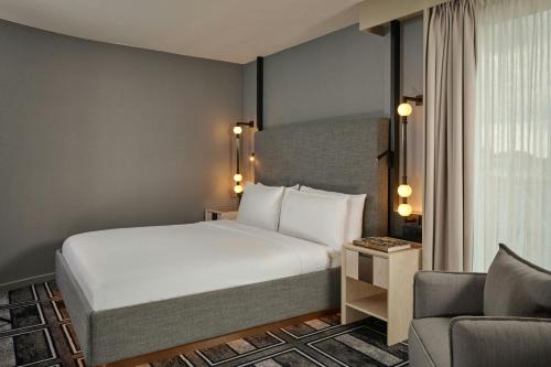 a hotel room with a bed and a couch at Ghent Marriott Hotel in Ghent