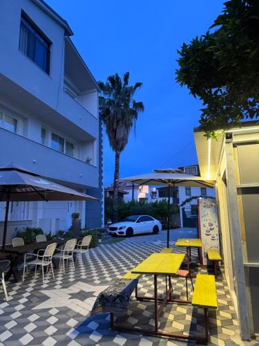 a patio with tables and chairs and a white car at Vila Cano Boutique in Durrës