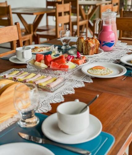 a table with plates of food and a cup of coffee at Môzzi Barra Grande in Barra Grande