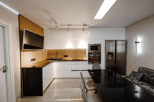 a kitchen with a table and a black refrigerator at Anna ApartHotel in Chişinău