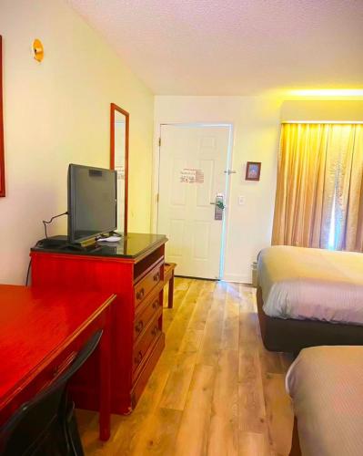 a hotel room with a bed and a desk with a television at Quality Inn in Bainbridge