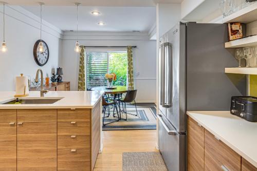 a kitchen with a stainless steel refrigerator and a table at Modern Home Close to Dtwn Woodinville with Yard in Woodinville