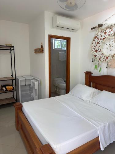 a bedroom with a bed and a bathroom with a toilet at Eco hotel el bosque in Doradal