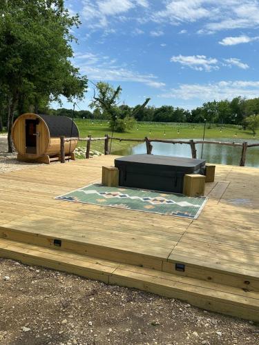 a bed on a wooden deck next to a lake at Boho Bliss Yurt - Unit # 4 in Woodway