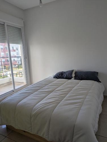 a bed in a bedroom with a large window at Beautiful apart with sea view in Tangier