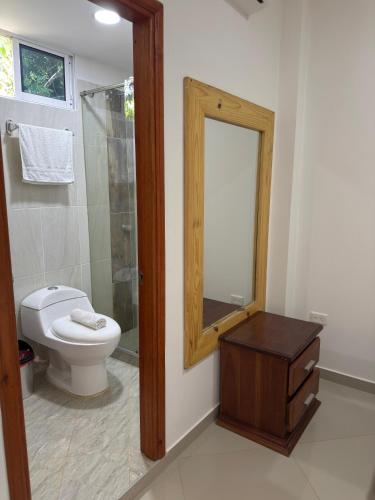 a bathroom with a toilet and a mirror at Eco hotel el bosque in Doradal