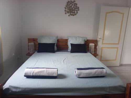 Un dormitorio con una cama grande con dos toallas encima. en L ombre du manguier, en Bonnet