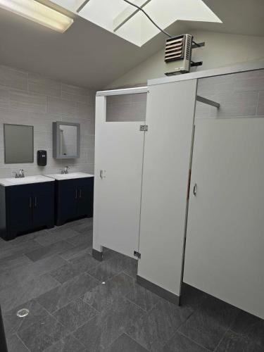 a bathroom with two sinks and a white door at Dockside Boat Rental Suite Rosario Ocean Views in Eastsound