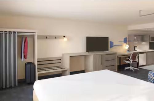 a hotel room with a bed and a desk with a television at Home2 Suites By Hilton Weston Ft. Lauderdale in Davie