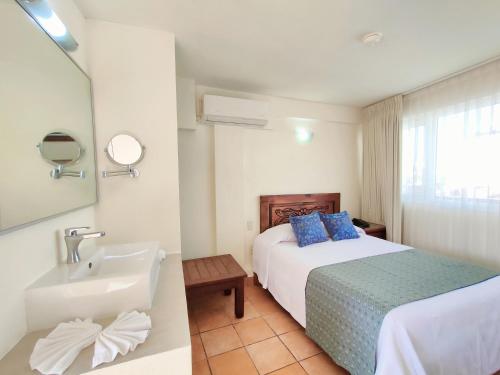 a hotel room with a bed and a sink at Hotel Rosita in Puerto Vallarta