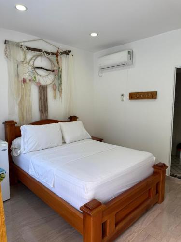 a bedroom with a large bed with white sheets at Eco hotel el bosque in Doradal