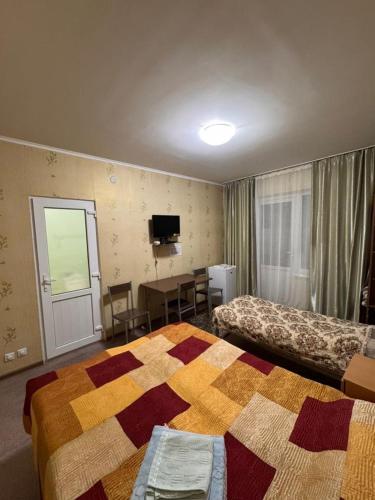 a hotel room with two beds and a table at Atlas in Cholpon-Ata