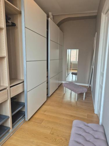 a walk in closet with a bench in a room at Centre ville Chambres dans un appartement d'exception in Bernay