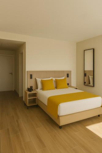 a bedroom with a large bed with yellow pillows at Hotel Infante Santo - Lisboa in Lisbon