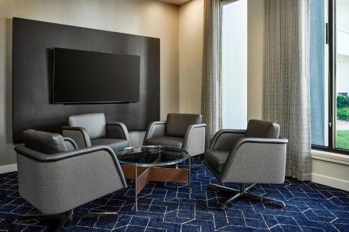 a waiting room with chairs and a flat screen tv at Courtyard by Marriott Boulder in Boulder