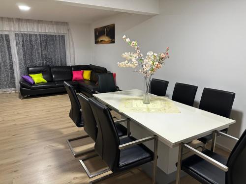 a living room with a white table and black chairs at Guest House BiBi-Lux in Ilsfeld