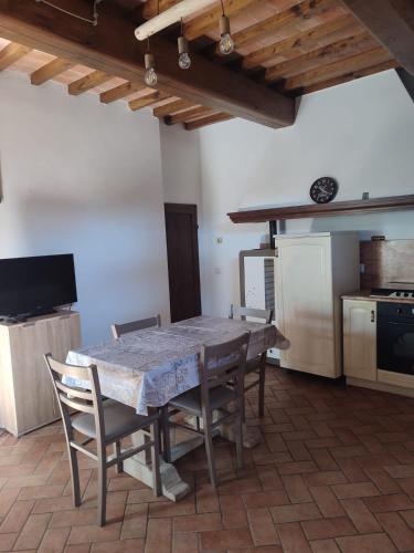 a kitchen with a table and chairs in a room at Casa vacanze nel bosco della Quercetina in Bibbiena