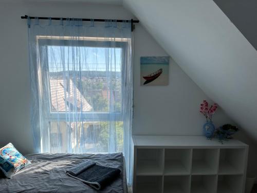a bedroom with a window and a bed and a stair case at Guest House BiBi-Lux in Ilsfeld