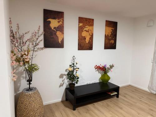 a room with three paintings on a wall with vases at Guest House BiBi-Lux in Ilsfeld