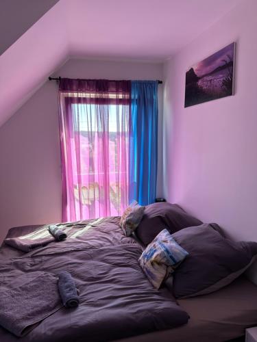 a bedroom with a bed in front of a window at Guest House BiBi-Lux in Ilsfeld